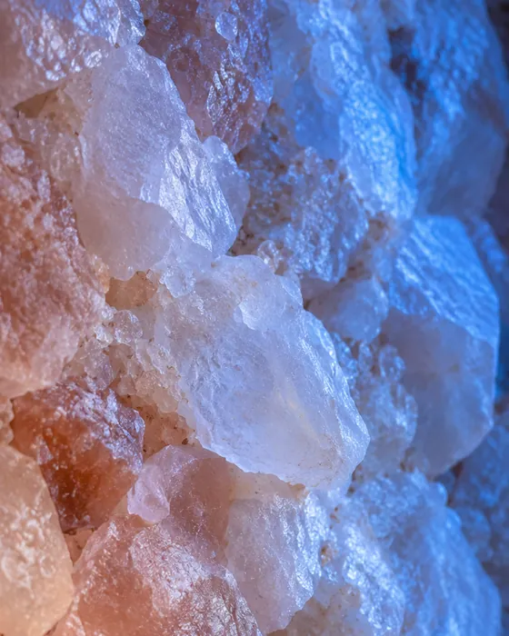 Cristalli di sale rosa da vicino, illuminati da una luce blu